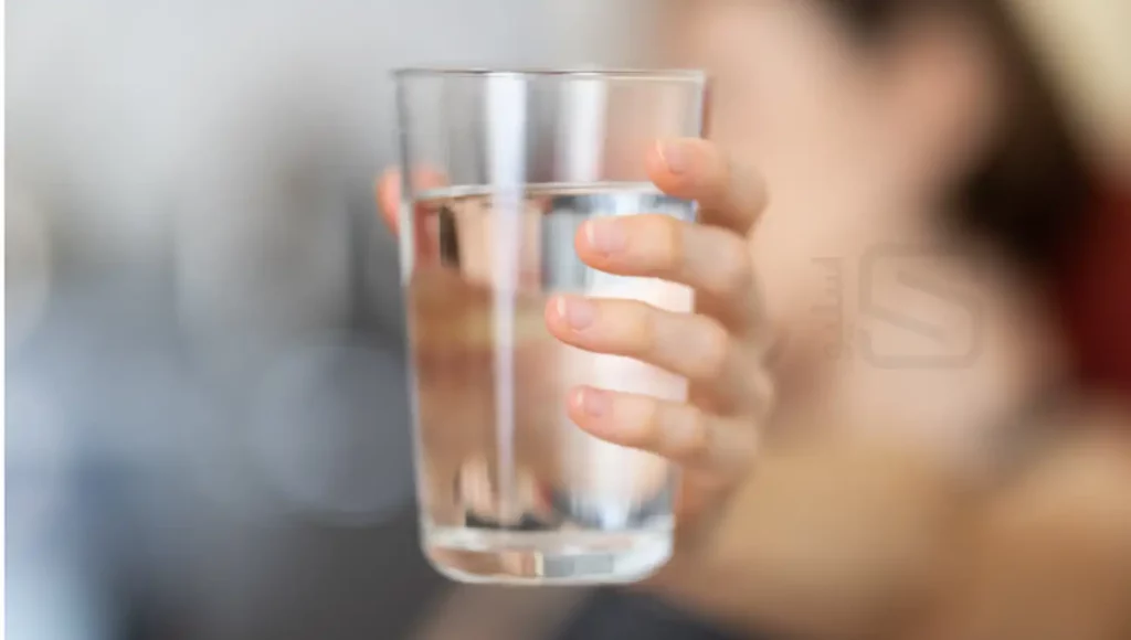 عکس خانمی که یک لیوان آب در دست دارد